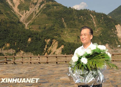 溫家寶總理十分關(guān)注災后重建進展情況。在國慶節(jié)和中秋佳節(jié)即將來臨之際，他第8次踏上了一直牽掛的這塊土地。在9月24日至26日的三天時間里，他奔波穿行于地震重災區(qū)的城鄉(xiāng)間，為節(jié)省時間，吃飯盡量安排在火車上；連續(xù)兩個晚上主持召開會議，就災后恢復重建的一系列重大問題進行研究部署。這是9月24日，溫家寶在青川縣紅光鄉(xiāng)東河口村地震遺址祭奠臺獻花。新華社記者黃敬文攝