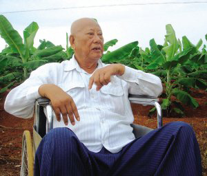 陳光保在自己的農(nóng)場(chǎng)里，他身后就是一片香蕉林(中青報(bào)蔣昕捷供圖)