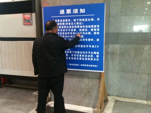 昨日，上海站，一位老人在認真研究退票新規(guī)。 李淑平 圖