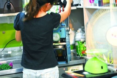 昨日，沙坪壩區(qū)一飲料店，店員在用添加劑勾兌果汁