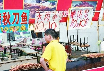 被查后，美食街上的'羊肉串'的'羊'字被涂抹了。