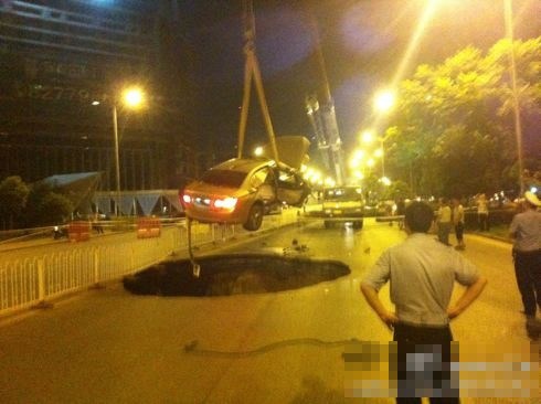 吊車將墜入塌陷坑的汽車吊出。圖/末代小王爺