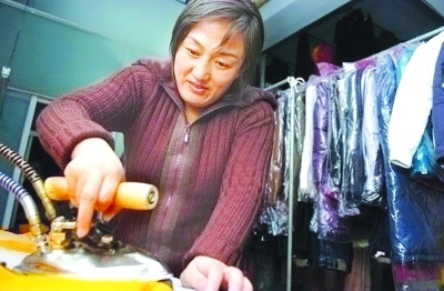 資料圖：鄒春蘭在自己洗衣店內(nèi)工作。圖片來(lái)源 揚(yáng)子晚報(bào)