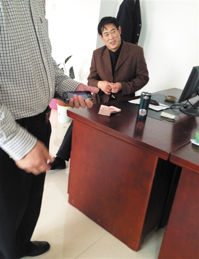 10月29日，獻縣國稅局稽查局辦公室內，一名企業(yè)主交了兩萬元現金在桌上。新京報記者 孟祥超 攝