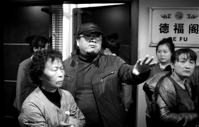 昨日，在河北香河天下第一城，相關(guān)負責人（左二）走出會議室與參加演出的老人們溝通。