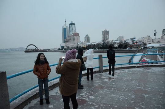 雪后棧橋顯露獨特韻味 游客不懼寒風(fēng)留影像
