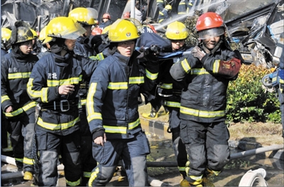 消防官兵將受傷的同事抬出。陳福 攝