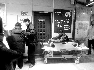 受傷工人小王坐在病床上候診。