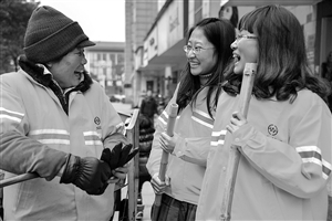 1月8日，22歲的王雪菁（右）和23歲的陶晨露（中）陪著她們的環(huán)衛(wèi)工人師傅鄧桂鸞聊天 新華社發(fā)