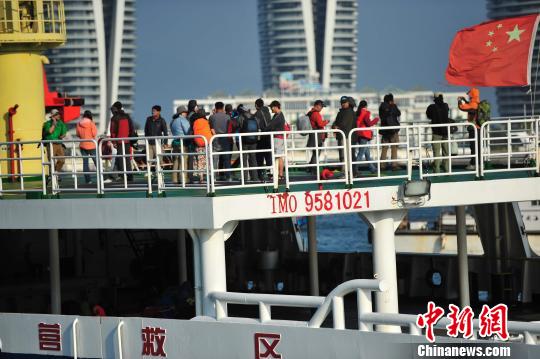 圖為24名“驢友”的“導游”被邊防的工作人員帶下船接受調(diào)查。 駱云飛 攝