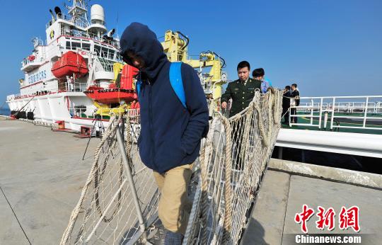 圖為24名“驢友”的“導(dǎo)游”被邊防的工作人員帶下船接受調(diào)查。 駱云飛 攝