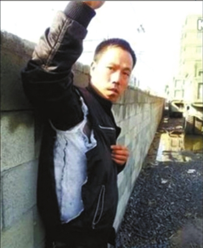 陳連弟向記者展示被撕壞的衣服。視頻截圖