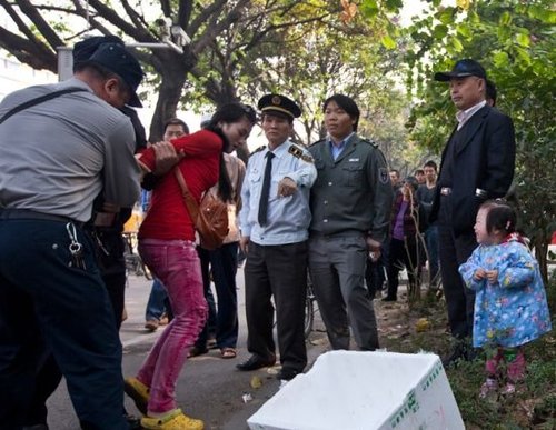 城管與女小販發(fā)生沖突后，女小販被警方強(qiáng)行帶走，她的孩子在一旁放聲大哭。南都記者 黎湛均 攝