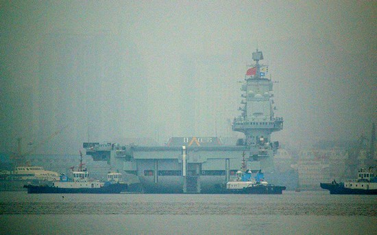 資料圖：大連港口大霧彌漫，中國(guó)首艘航母“遼寧艦”徐徐離開(kāi)港口。