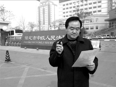 焦占軍在法院門口拿著決定書，無語站立。京華時報記者孫思婭攝